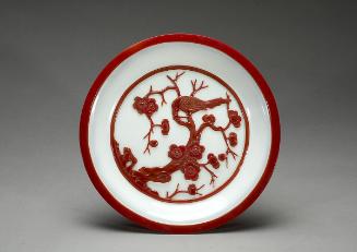 White plate with a scene of plum and magpie in opaque red overlay