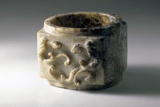 Tube in an ancient form with dragons in relief