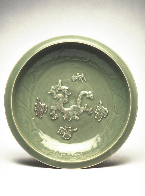 Plate with applied dragon amid clouds