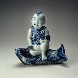 Water dropper with design of a boy sitting on a carp