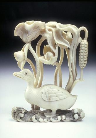 Carving of duck in stream under lotus