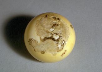 Netsuke of monkey, holding a branch of persimmon, being attacked by a bee